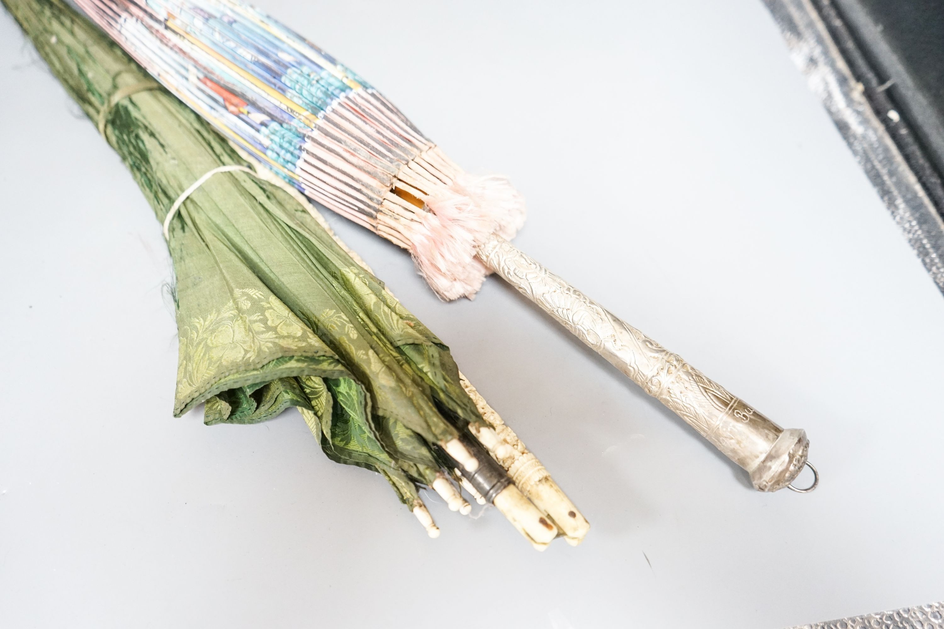 A 19th century Chinese Canton export ivory parasol with carved Ivory handle and a Burmese white metal handled painted fabric parasol